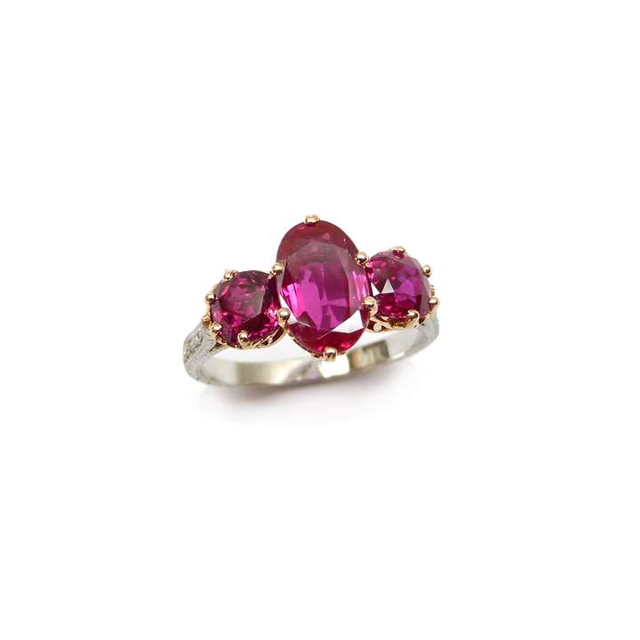 Three stone Burma ruby ring, centred by an oval ruby of 2.16ct